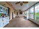 Bright sunroom featuring neutral carpet, numerous windows, ceiling fan, and backyard access at 4416 Flagg St, Orlando, FL 32812