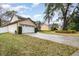 Suburban home featuring a well-kept lawn, a two-car garage, and a neatly trimmed hedge along the driveway at 445 Autumn Oaks Pl, Lake Mary, FL 32746