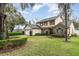 Well-maintained two-story home with a manicured lawn, mature trees, and a two-car garage on a sunny day at 445 Autumn Oaks Pl, Lake Mary, FL 32746