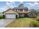 Charming two-story home with a well-manicured lawn, mature trees, and a two-car garage at 445 Autumn Oaks Pl, Lake Mary, FL 32746