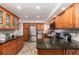 Well-equipped kitchen featuring stainless steel appliances, granite countertops, wooden cabinetry, and tile flooring at 445 Autumn Oaks Pl, Lake Mary, FL 32746