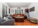 Comfortable living room featuring a leather sofa, hardwood floors, neutral decor, and natural light from the windows at 445 Autumn Oaks Pl, Lake Mary, FL 32746