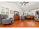 Bright living room with hardwood floors, a vaulted ceiling, comfortable seating, and large windows at 445 Autumn Oaks Pl, Lake Mary, FL 32746