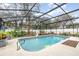 Private pool with a screen enclosure surrounded by lush landscaping and a clean patio at 445 Autumn Oaks Pl, Lake Mary, FL 32746