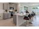 Stylish kitchen with stainless steel appliances, gray cabinetry, quartz countertops, and barstool seating at 479 Taylor Groves Dr, Lake Wales, FL 33898