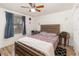 Cozy bedroom featuring a wooden bed frame, ceiling fan, and window with blue curtains at 537 Martin Place Blvd, Apopka, FL 32712