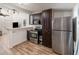 Functional kitchen featuring stainless steel appliances, dark wood cabinets and wood flooring at 537 Martin Place Blvd, Apopka, FL 32712