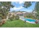 Backyard view featuring a swimming pool, lawn area, and a screened-in porch of the home at 616 Sheridan Blvd, Orlando, FL 32804