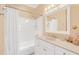 Bright bathroom featuring a bathtub with shower, vanity with sink and mirror, and seashell decor at 616 Sheridan Blvd, Orlando, FL 32804