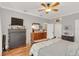 Cozy bedroom with a ceiling fan, hardwood floors, dresser, and soft, natural light at 616 Sheridan Blvd, Orlando, FL 32804