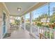 Spacious porch with white columns, comfortable wicker furniture, and red geraniums in white flower boxes at 616 Sheridan Blvd, Orlando, FL 32804