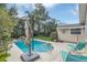 Backyard pool with umbrella, grassy area, and view of the pool house with a sun decoration at 616 Sheridan Blvd, Orlando, FL 32804