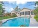 Backyard view of the pool with stone trim, lawn area, screened room, and lounge chairs at 616 Sheridan Blvd, Orlando, FL 32804