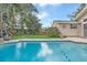 Beautiful swimming pool with stone trim surrounded by a lush landscaped backyard and lawn at 616 Sheridan Blvd, Orlando, FL 32804