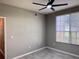 Bedroom featuring neutral walls and a ceiling fan, complemented by natural light from the window at 6408 Raleigh St # 2402, Orlando, FL 32835