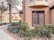 Condo building exterior featuring well-maintained landscaping and double door entry way at 6408 Raleigh St # 2402, Orlando, FL 32835