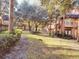 Grassy courtyard with mature shade trees, bench and sidewalks in a well-maintained condo community at 6408 Raleigh St # 2402, Orlando, FL 32835