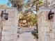 Stone entrance with iron lanterns, a brick walkway, and lush landscaping in a condo community at 6408 Raleigh St # 2402, Orlando, FL 32835