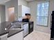 Modern kitchen with tile floors, ample cabinet space, stainless steel sink, and black appliances at 6408 Raleigh St # 2402, Orlando, FL 32835