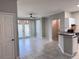 Open living room features tile flooring, ceiling fan, access to kitchen and bright balcony doors at 6408 Raleigh St # 2402, Orlando, FL 32835