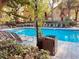 Community pool with lounge chairs, lush landscaping, palm trees and nearby condos at 6408 Raleigh St # 2402, Orlando, FL 32835