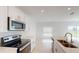 Well-lit kitchen boasting stainless steel appliances, a double sink, a smooth cooktop, and white cabinets at 670 Teviot Rd, Haines City, FL 33844