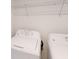 Bright laundry room features a standard washer and dryer with overhead wire shelving at 670 Teviot Rd, Haines City, FL 33844