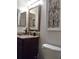 Bathroom vanity featuring a granite countertop, bronze fixtures and a decorative wall mirror at 7138 Hiawassee Bent Cir, Orlando, FL 32818