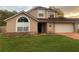 Charming two-story home features a manicured lawn, attached garage, and a welcoming facade with large windows at 7138 Hiawassee Bent Cir, Orlando, FL 32818