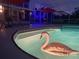 Twilight view of the screened in pool and patio with a swan float and exterior lights at 7138 Hiawassee Bent Cir, Orlando, FL 32818