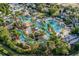 Stunning aerial view of a resort-style pool with lush tropical landscaping and winding waterways at 7433 Excitement Dr, Reunion, FL 34747