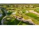 Scenic aerial view of a meticulously maintained golf course with sand traps and rolling green hills at 7433 Excitement Dr, Reunion, FL 34747