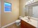 Bathroom with a frosted window, patterned wallpaper, toilet, and a wood cabinet vanity at 8348 Via Rosa, Orlando, FL 32836