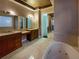 Luxurious bathroom with dual vanities, a makeup area, and a jetted tub at 8348 Via Rosa, Orlando, FL 32836