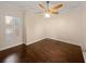 Neutral bedroom with hardwood floors, ceiling fan, and window with wooden blinds at 8348 Via Rosa, Orlando, FL 32836