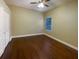 Bedroom features warm paint, hardwood floors, ceiling fan and a sunny window at 8348 Via Rosa, Orlando, FL 32836