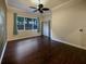 Inviting bedroom with a ceiling fan, hardwood floors, and a large window at 8348 Via Rosa, Orlando, FL 32836