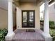 Inviting entrance to a home with glass double doors framed by large columns and brick walkway at 8348 Via Rosa, Orlando, FL 32836