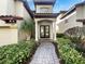 Inviting front entrance with beautiful landscaping, brick walkway, and double doors at 8348 Via Rosa, Orlando, FL 32836