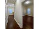 Hallway view shows beautiful hardwood floors leading to a bedroom with bright window at 8348 Via Rosa, Orlando, FL 32836