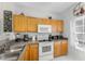 Kitchen features wooden cabinets, white appliances, and grey countertop at 8523 Crystal Cove Loop, Kissimmee, FL 34747