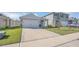 Exterior shot of a well-maintained, one-story home with a two-car garage and tidy landscaping at 863 August Sky Dr, Deltona, FL 32738