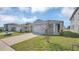 Inviting front exterior of home featuring a lush lawn, and wide driveway at 863 August Sky Dr, Deltona, FL 32738