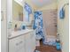 Clean bathroom features a sink vanity, toilet, and a walk-in shower with blue floral accents at 8982 Fort Jefferson Blvd, Orlando, FL 32822