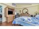 Well-lit bedroom with wooden floors, a TV, a round mirror, and a cozy bed with blue floral bedding at 8982 Fort Jefferson Blvd, Orlando, FL 32822