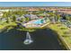 Overhead view of the community clubhouse and pool overlooking a scenic pond with fountain at 9406 Mere Pkwy, Orlando, FL 32832