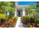 Eye-level shot of a home's entrance featuring tropical landscaping and a gated entry at 9406 Mere Pkwy, Orlando, FL 32832