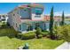 Rear view of a two-story home highlighting well-maintained landscaping and a tiled roof at 9406 Mere Pkwy, Orlando, FL 32832