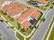 Aerial view of a home's rear exterior featuring a pool, covered patio, and well-manicured lawn with a stylish tile roof at 9406 Mere Pkwy, Orlando, FL 32832