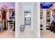 Bright walk-in closet featuring custom shelving and a central hallway to the en-suite bathroom at 9406 Mere Pkwy, Orlando, FL 32832